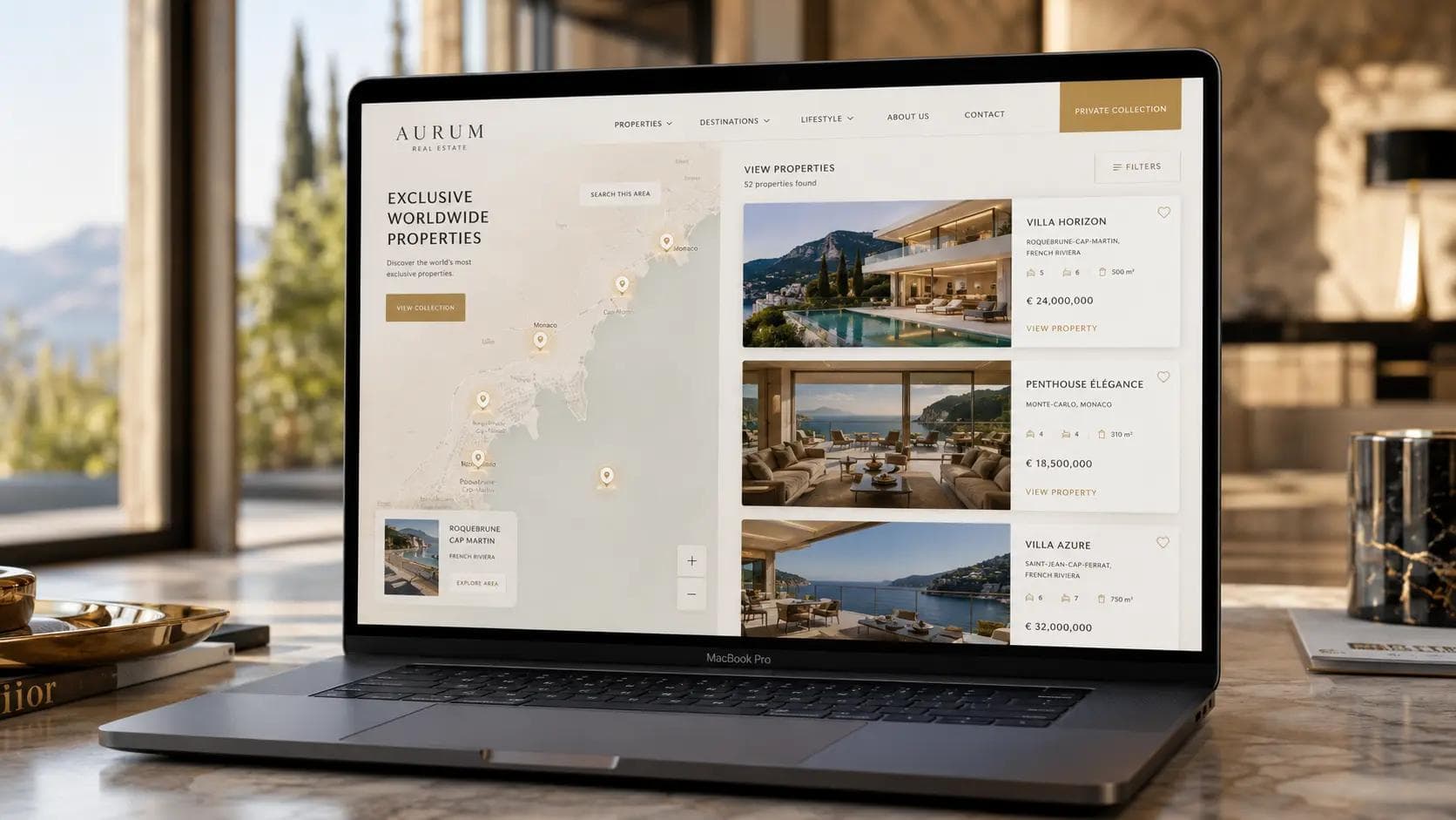 Luxury real estate website displayed on a MacBook Pro featuring an interactive property map, premium property listing cards, modern villa photography, elegant beige and white UI design with gold accents in a high-end architectural studio setting.